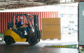 man operating forklift and carrying a load to weigh on a scale
