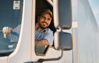 smiling male truck driver leaning out window