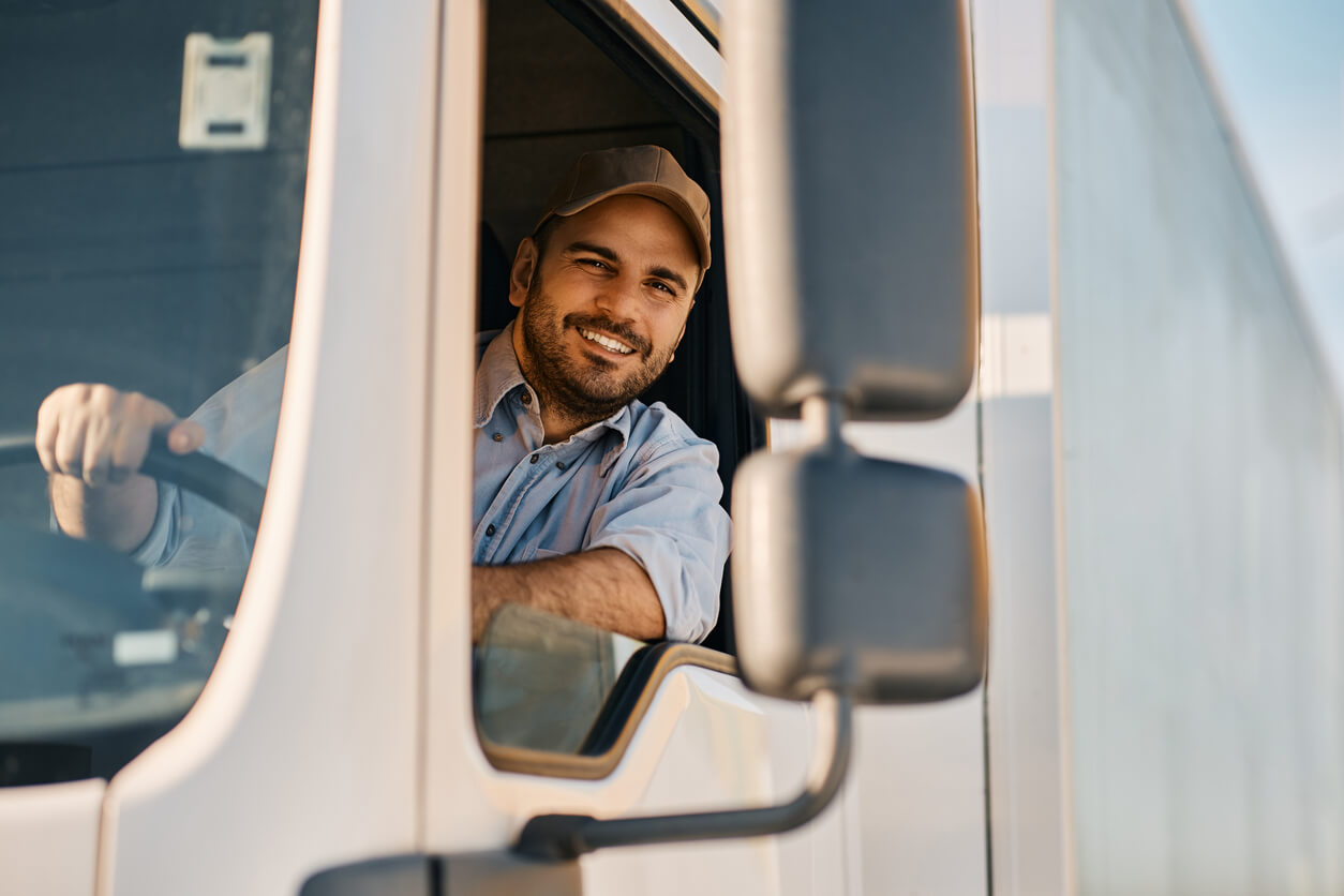 smiling male truck driver leaning out window